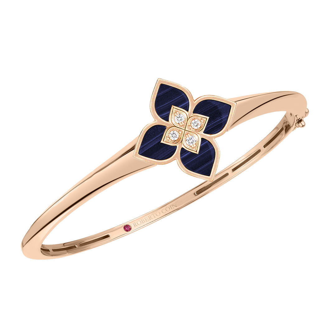 The Roberto Coin Princess Flower 18K Rose Gold Diamond with Lapis Bangle boasts a captivating flower-shaped ornament, enriched with deep blue lapis petals and a brilliant diamond centerpiece.