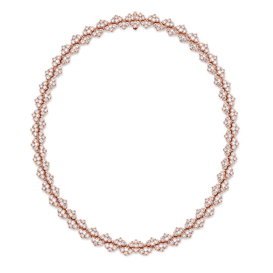 The Roberto Coin Cobra 18K Rose Gold Pave Diamond Collar Necklace features an intricate design, with clusters of sparkling white diamonds elegantly arranged around the rose gold chain to form a captivating circular silhouette reminiscent of a delicate diamond collar.