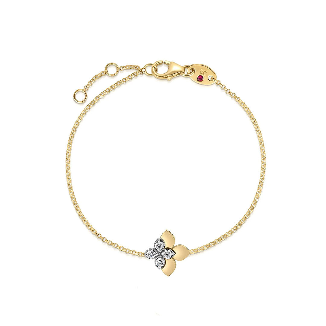 The Roberto Coin Love in Verona Stud 18K Yellow Gold Diamond Flower Bracelet features a fine gold chain, a diamond flower charm, an adjustable clasp with a small red gem, and draws inspiration from Roberto Coin’s signature style.