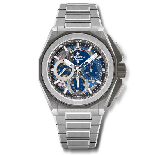 The ZENITH Defy Extreme El Primero 21 Automatic Chronograph 45mm Watch showcases a strong and athletic design, accentuated by its metallic titanium strap and bezel. The eye-catching blue dial includes several chronograph sub-dials and silver hour markers, with the Zenith brand name prominently displayed on the face.