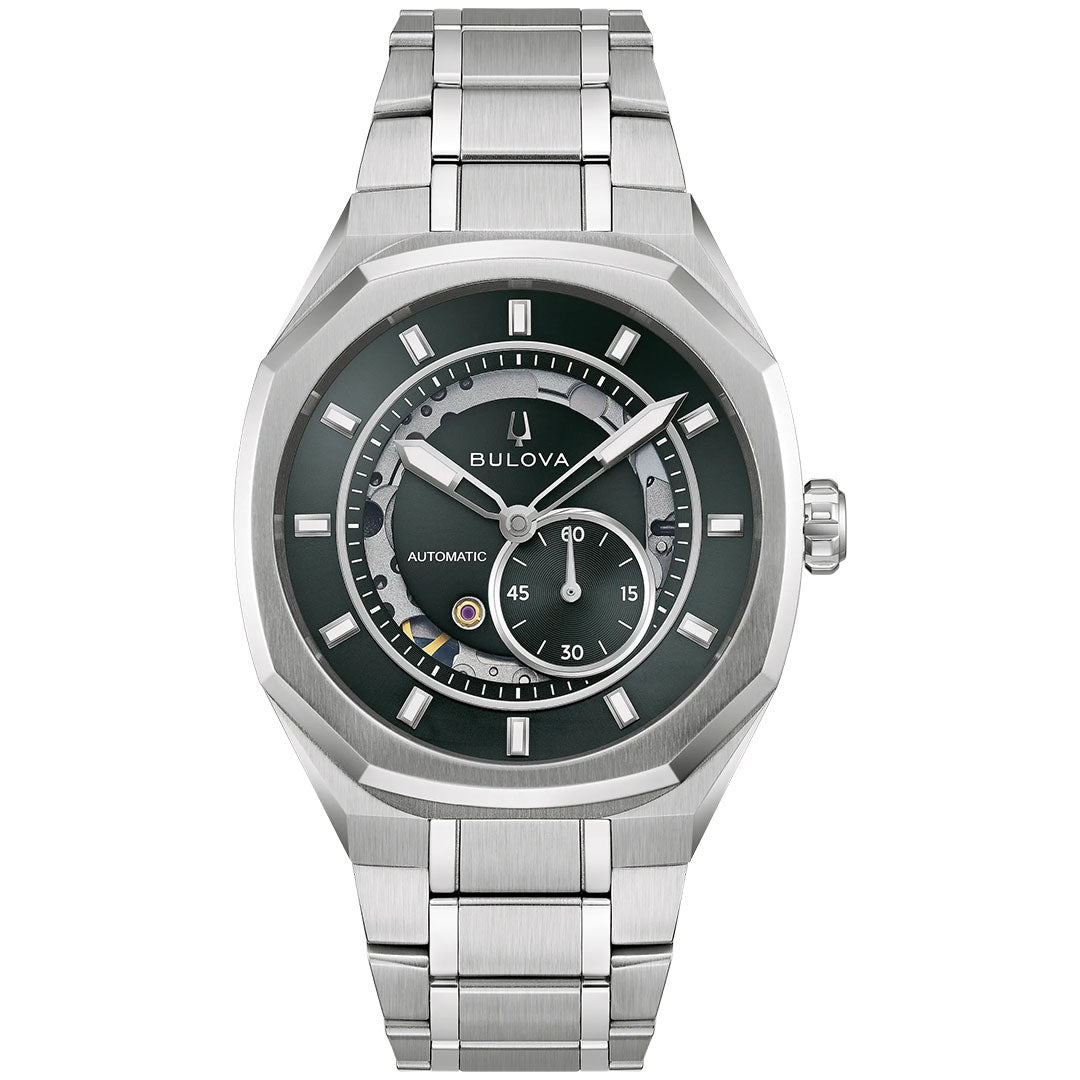 The Bulova Surveyor Marc Anthony Automatic 40.5mm Watch features a silver-tone stainless steel link band, a dark dial with geometric hour markers and subdials, and automatic movement; it’s shown from the front against a white background.
