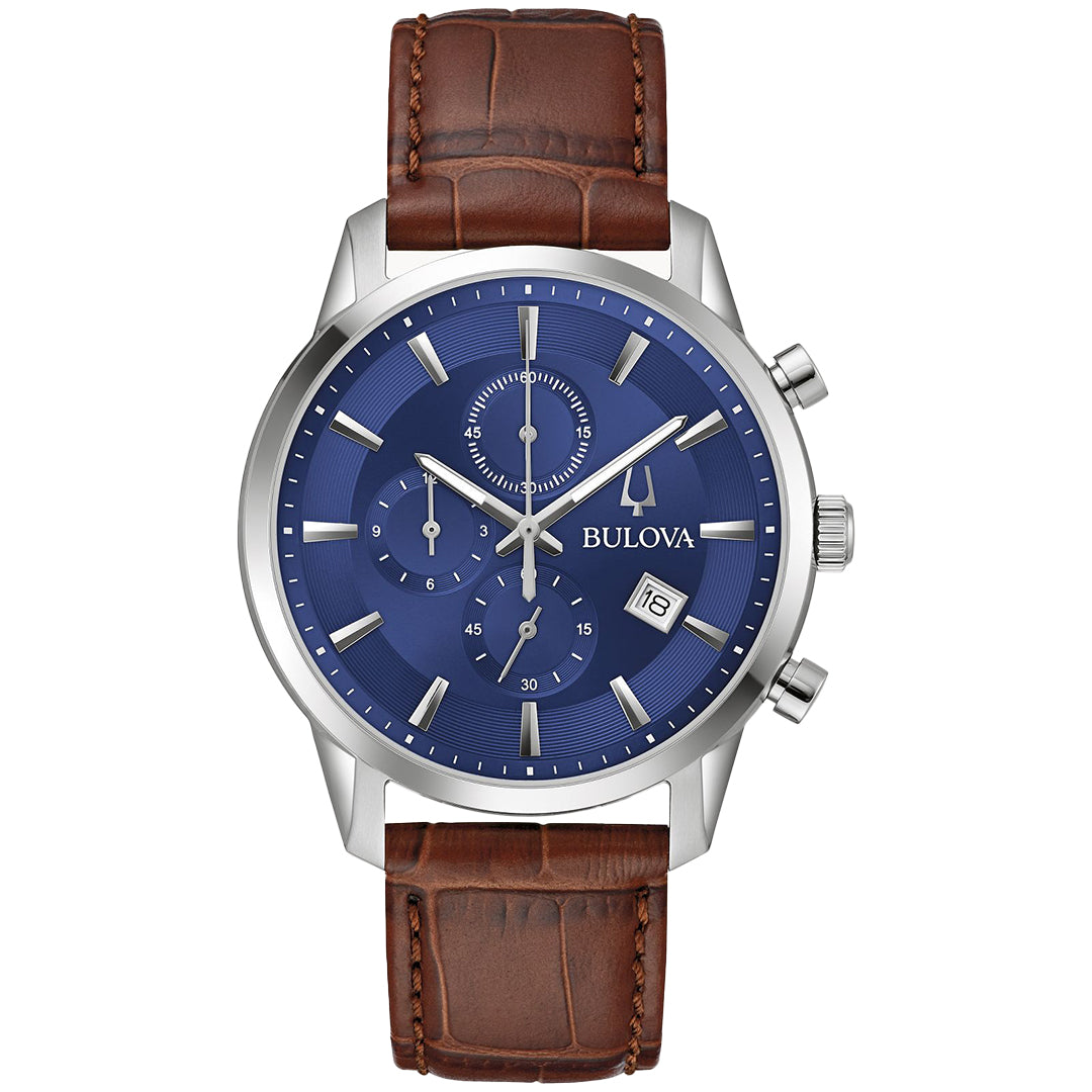 This Bulova Sutton Quartz 41mm watch, part of the Sutton Collection, boasts a silver-tone stainless steel case, blue dial with silver hour markers and triple sub-dials. It features a date window at 4 o'clock and comes with a brown crocodile-patterned leather strap.