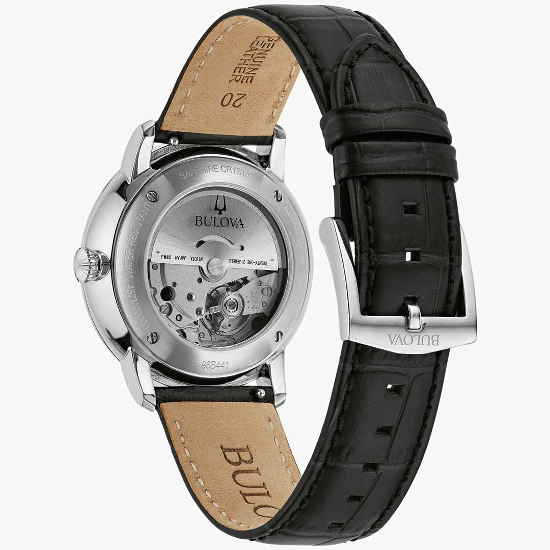 The Bulova Hudson Automatic 39mm Watch features a sophisticated black leather strap and is showcased face down to exhibit its transparent case. This elegant timepiece reveals its automatic movement and intricate design details, accentuated by a sturdy sapphire crystal. The brand name "Bulova" graces both the clasp and back.