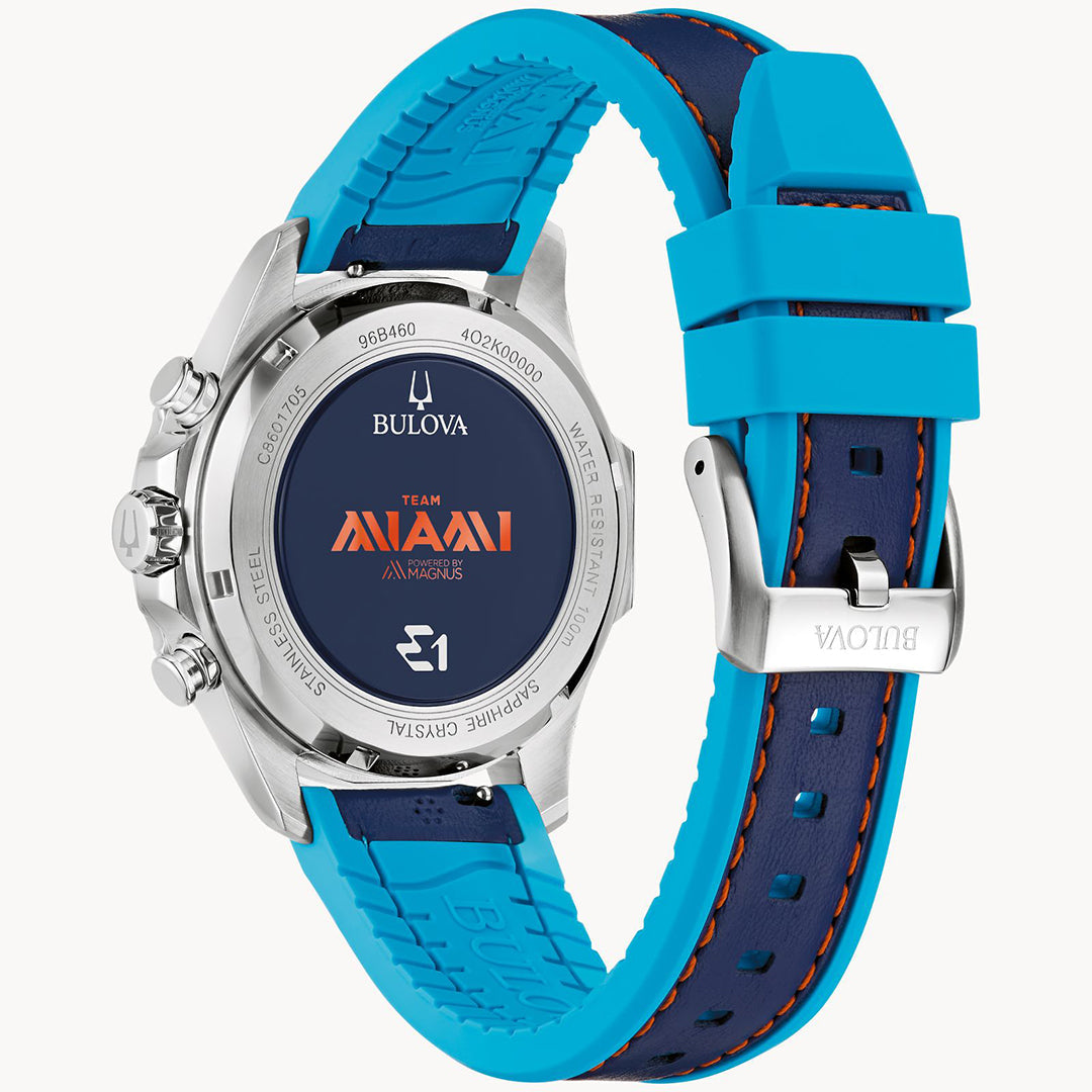 The Bulova E1 Team Miami Quartz 43mm Watch is a silver timepiece with a blue/orange Miami logo on the backplate. Inspired by electric boat racing, it features a blue/orange silicone strap, stainless steel casing with visible buttons, water resistance, and an engraved clasp.