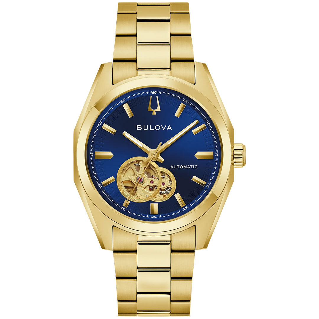 The Bulova Surveyor Automatic 39mm Watch is a gold men’s timepiece featuring a striking blue dial with gold hour markers and an open heart mechanical movement visible at the 8 o’clock position. It is finished with a matching gold metal band.