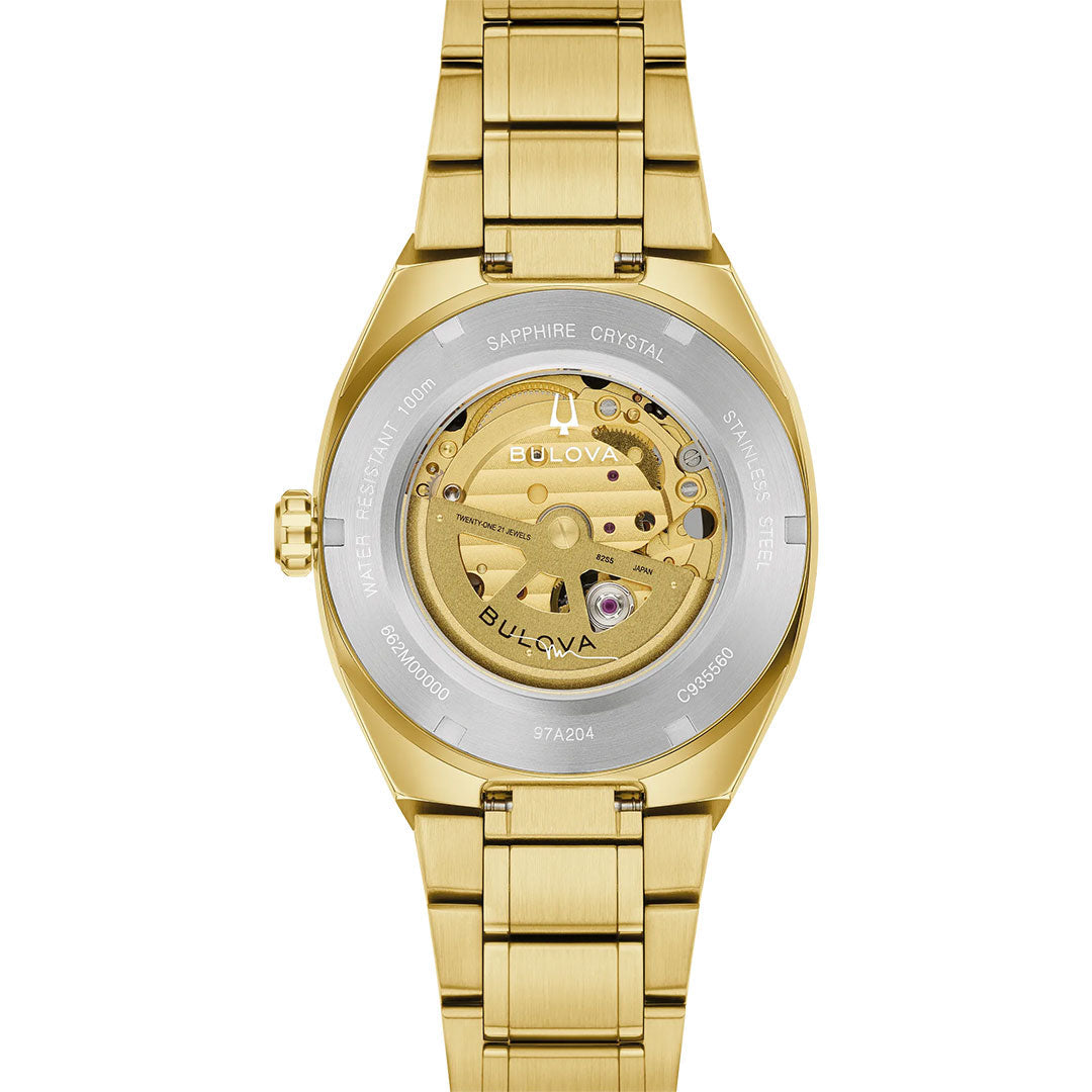 Back view of the Bulova Surveyor Marc Anthony Automatic 40.5mm Watch, showcasing a gold-tone stainless steel case and a transparent caseback that displays the detailed automatic movement within, all encircled by engraved metal specifications.