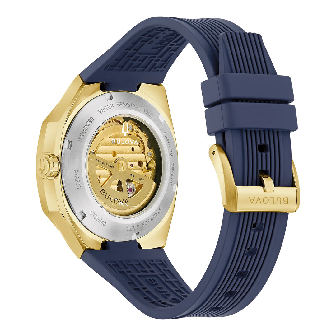 The Bulova Surveyor Marc Anthony Automatic 40.5mm Men’s Watch features a gold-tone stainless steel case with an exposed automatic movement and a bold blue silicone strap. The watch back reveals the internal gears, while the Bulova logo is engraved on both the clasp and inside the case.