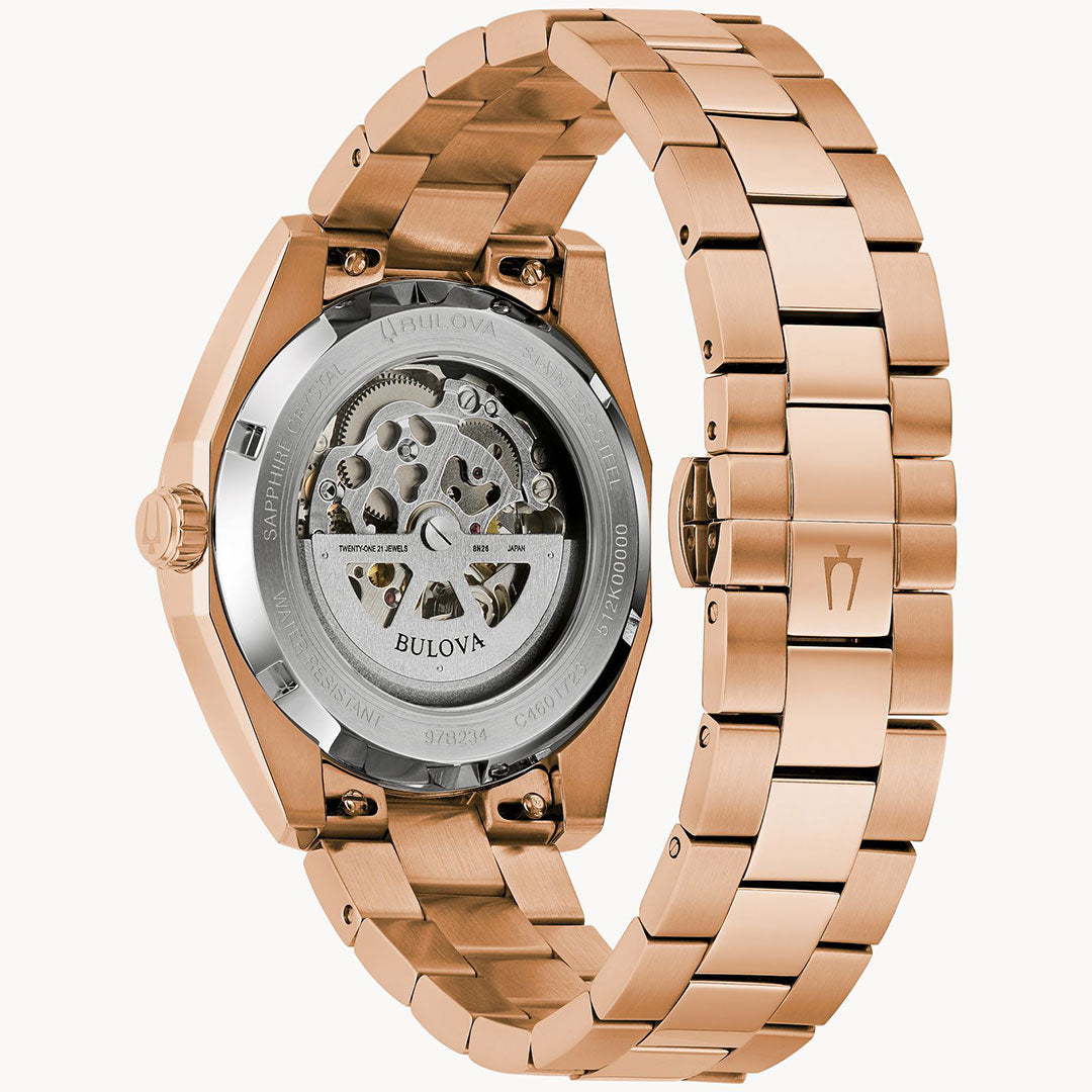 Back view of the Bulova Surveyor Automatic 39mm watch, featuring a rose gold-tone metal link band and a transparent case back revealing its movement.