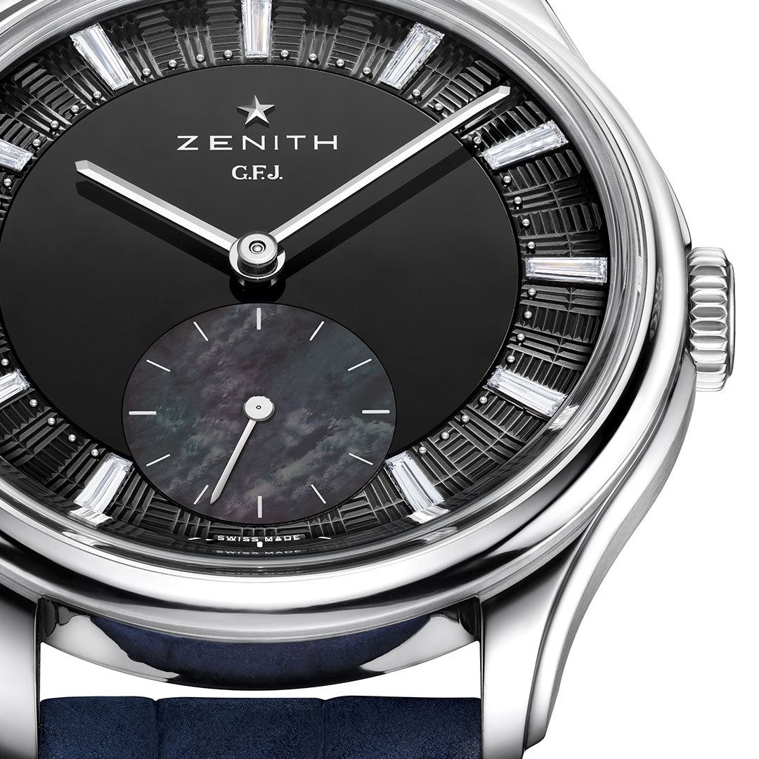 Close-up of the Zenith G.F.J. Tantalum Calibre 135 Automatic 39.15mm watch, featuring a black dial, silver hands, baguette-cut diamond markers, a small seconds sub-dial, and a blue leather strap in a polished case.