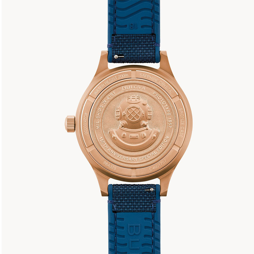 The Bulova MIL Ships CUSN8 Bronze Archive Series Automatic 41mm Watch features a bronze case with vintage diving helmet engravings and comes paired with a blue textured strap for timeless style.