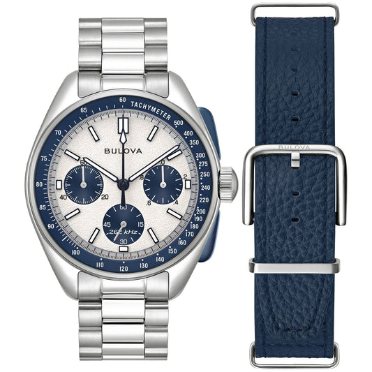 The Bulova Lunar Pilot Quartz 43.5mm Watch, crafted by Bulova, features a sophisticated silver chronograph design with precision quartz movement. The watch has a striking blue and white dial complete with a tachymeter and includes three sub-dials. It offers versatility and style through its interchangeable textured blue leather strap and is complemented by a stainless steel bracelet.