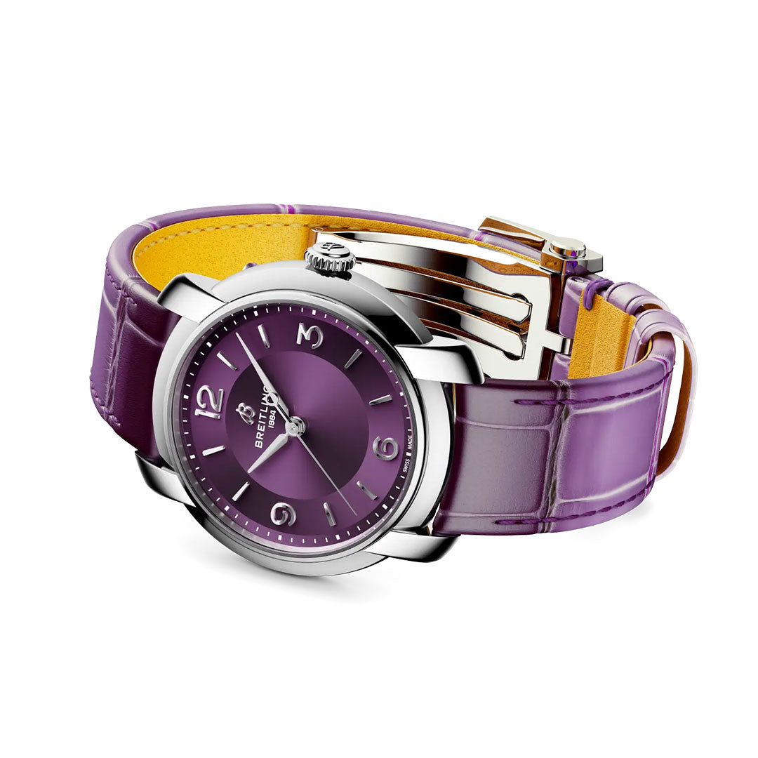 The BREITLING Lady Premier Automatic 36 is a stylish Breitling women’s watch with a shiny purple dial, silver markers, and a textured purple leather strap with a metal clasp.