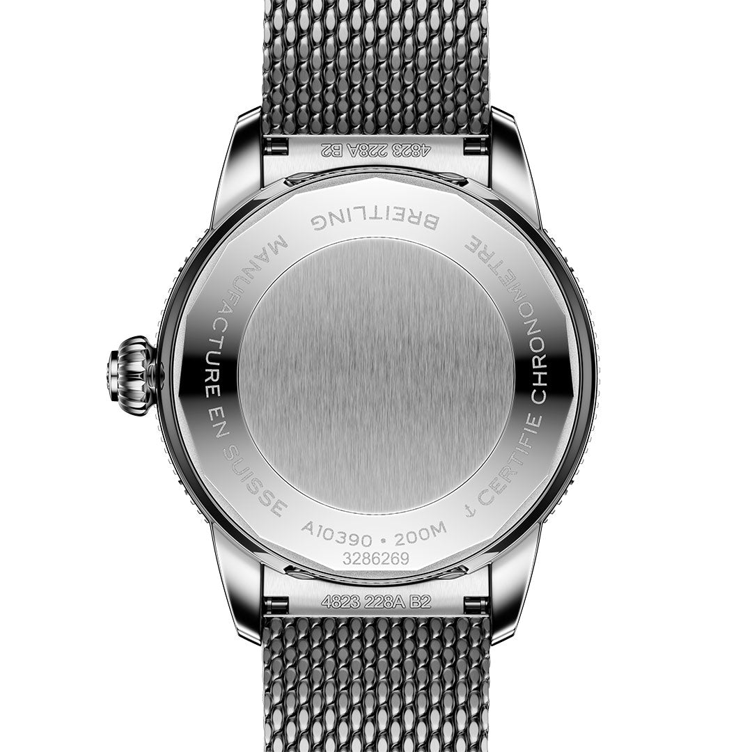 The back of a BREITLING Superocean Heritage B31 Automatic 36 features a stainless steel mesh band, engraved with the Breitling brand, model details, water resistance info, and certification around a plain circular center.