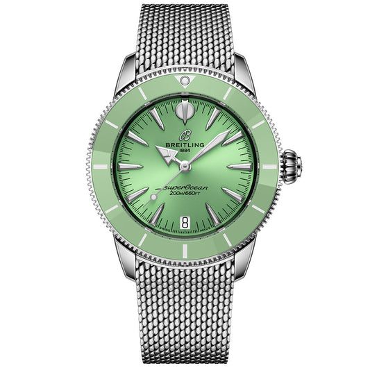 The BREITLING Superocean Heritage B31 Automatic 36 by Breitling features a green dial, ceramic bezel, silver hour markers, date window at 6 o’clock, silver mesh bracelet, and a stainless steel case.