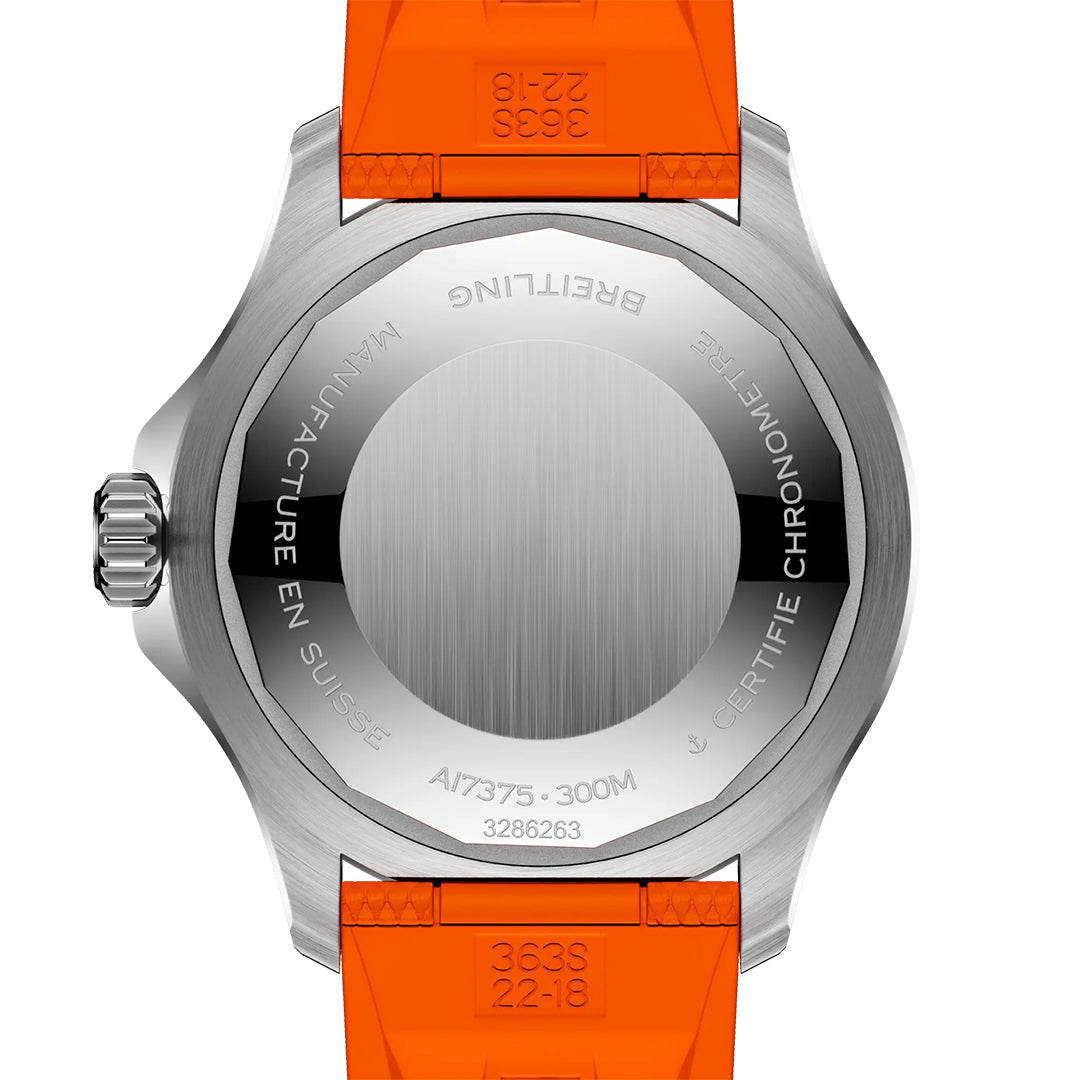 Back of the BREITLING Superocean Automatic 42 by Breitling with an orange strap, featuring engraved stainless steel case details, visible certification, water resistance info, luminescent indexes, and left-side crown.
