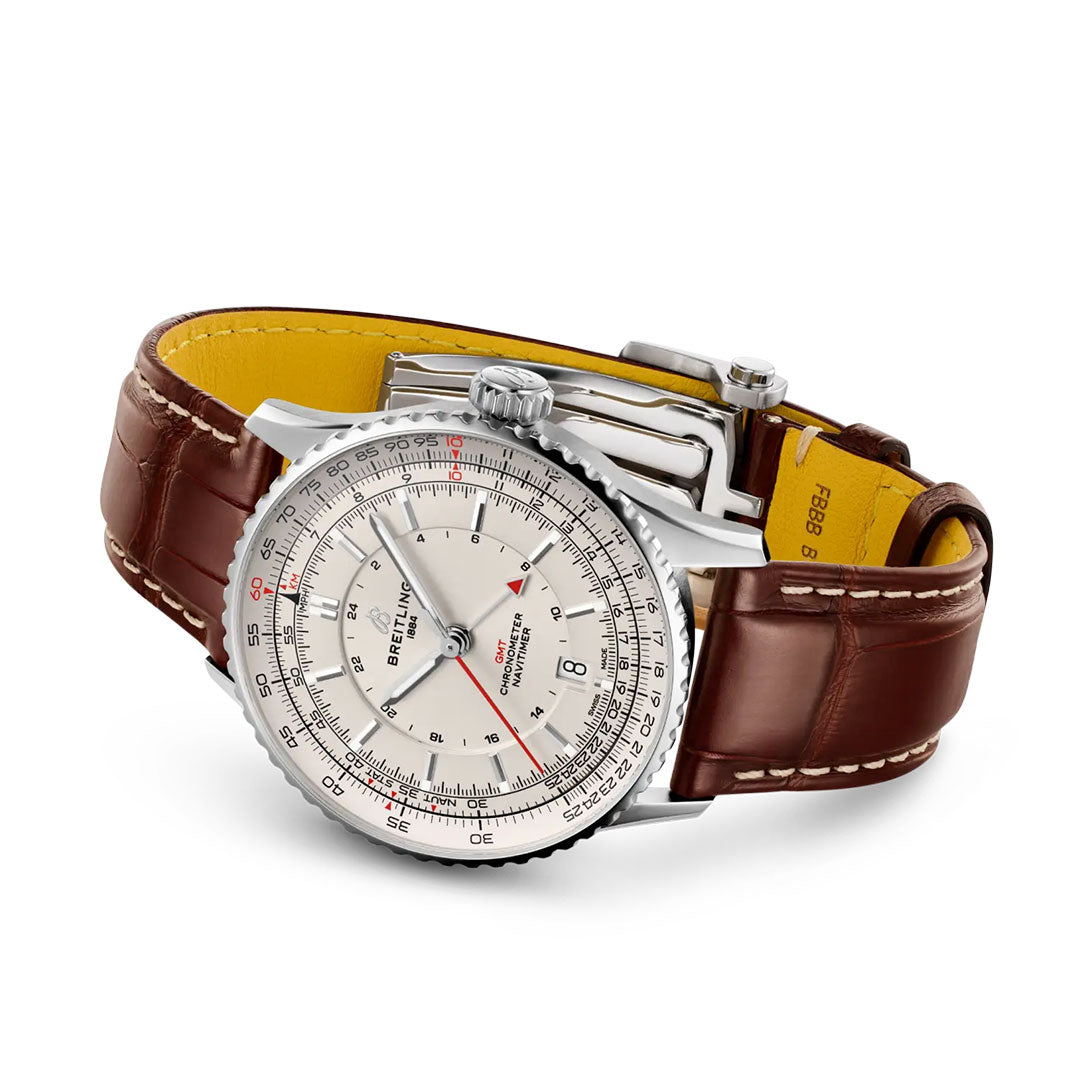 The Breitling Navitimer Automatic GMT 41 features a silver case, cream dial with multiple scales, and a brown leather strap with white stitching and yellow lining—a classic luxury pilot watch.