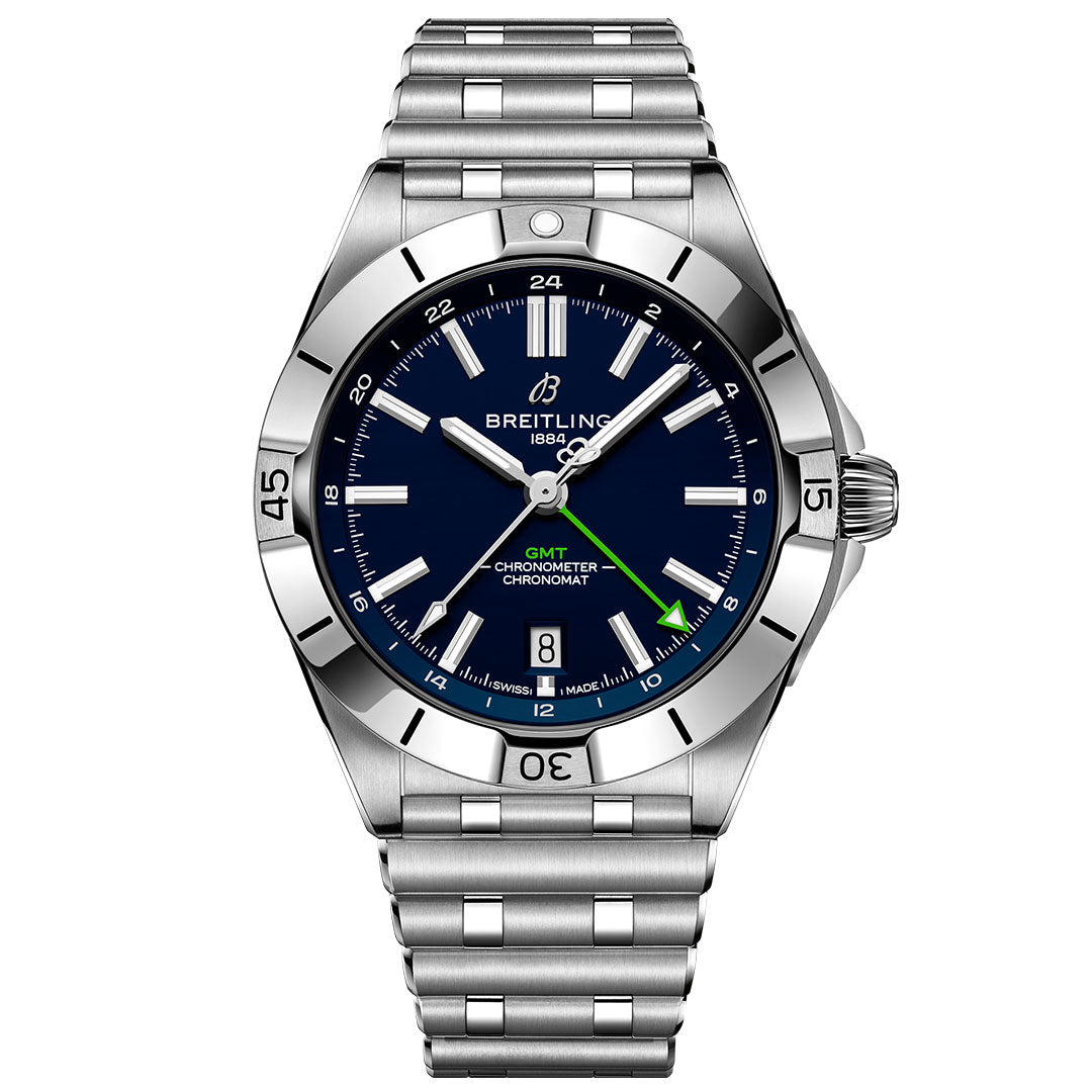 The BREITLING Chronomat Automatic GMT 40 features a stainless steel case, blue dial, silver markers and hands, a green GMT hand, date at 6 o’clock, link bracelet, and a bezel with engraved numerals and markers.