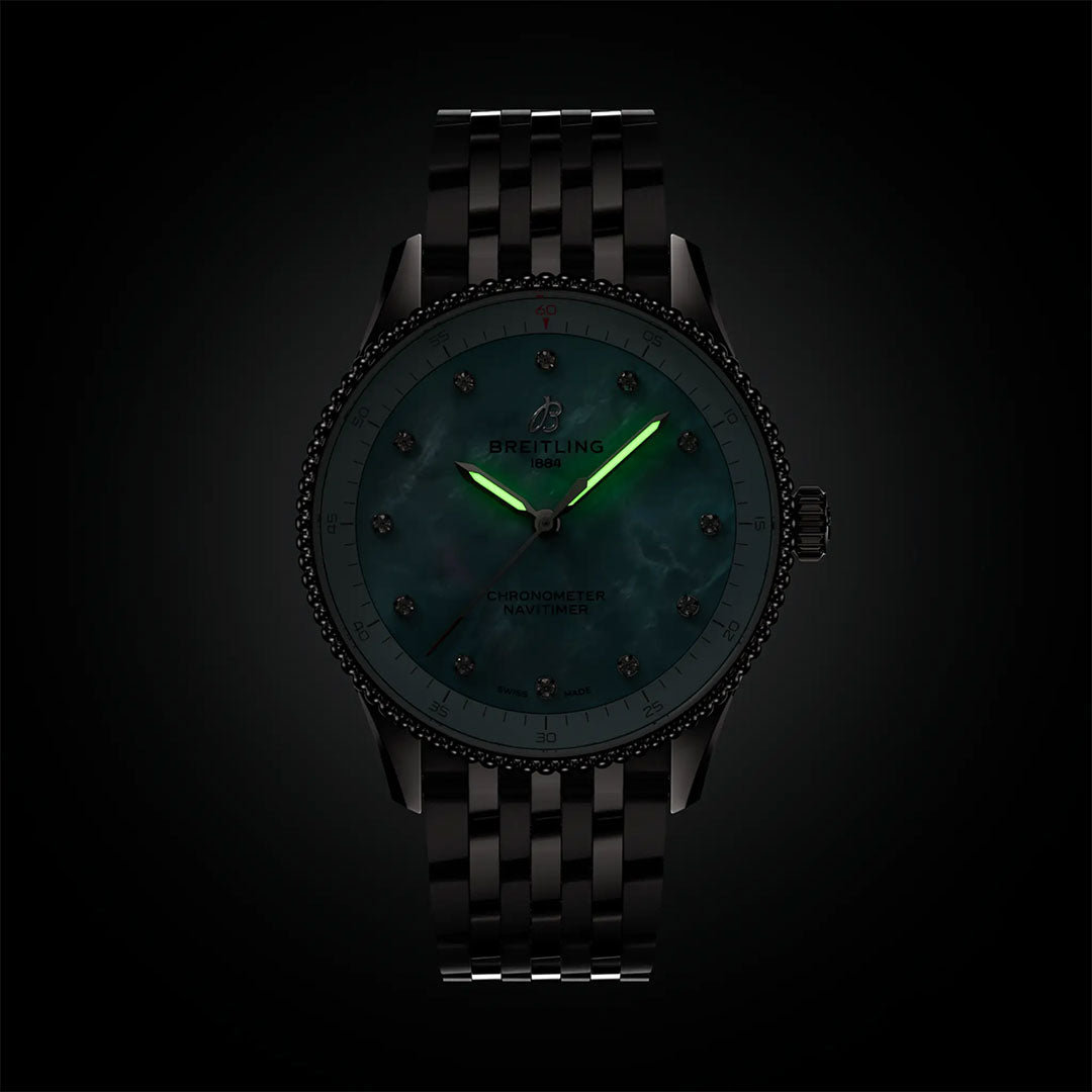 The BREITLING Navitimer 32 by Breitling is featured with a dark teal dial, glowing green hour and minute hands, and a black metal link band, highlighting its refined luxury style against a dark background.