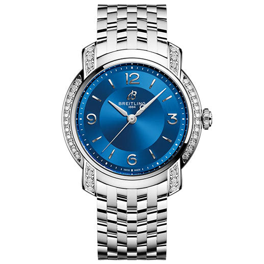 The BREITLING Lady Premier 32 by Breitling is a luxury watch with a silver metal link band, a round blue dial, silver hour markers, and sparkling diamonds set along the watch face.