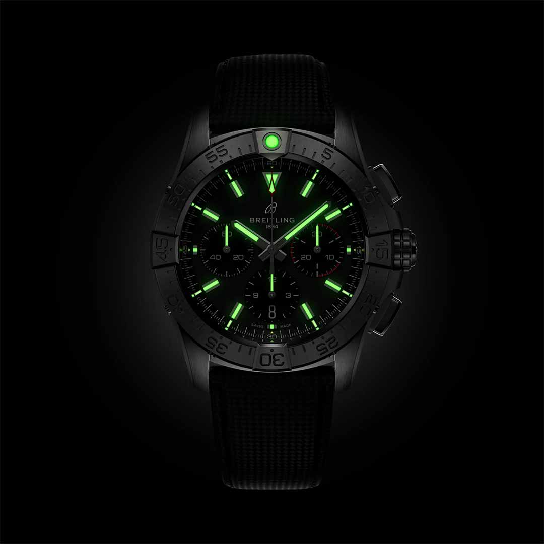 The BREITLING Avenger B01 Chronograph 42 features luminescent green hour markers and hands set against a black background, embodying an aviation style. Its black strap reflects the sleek sophistication of jet pilots, while the dial displays a logo and precise markings, completing its design inspired by military leather straps.