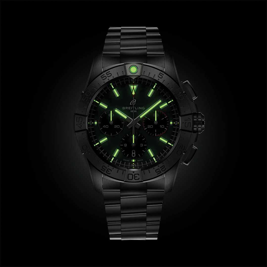 The BREITLING Avenger B01 Chronograph 42 by Breitling showcases an aviation style with its black wristwatch design, featuring glowing green markers and hands against a dark background. The watch face, inspired by the precision of an Avenger, includes multiple dials. Its metal band perfectly complements the sleek, modern design.