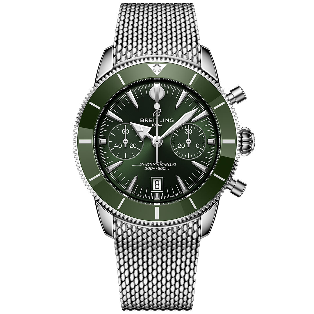 The BREITLING Superocean Heritage B01 Chronograph 42 features a green bezel and dial, silver hour markers, three subdials, a date window at 6 o’clock, and a silver mesh stainless steel strap. Powered by the Breitling Manufacture Caliber 01.