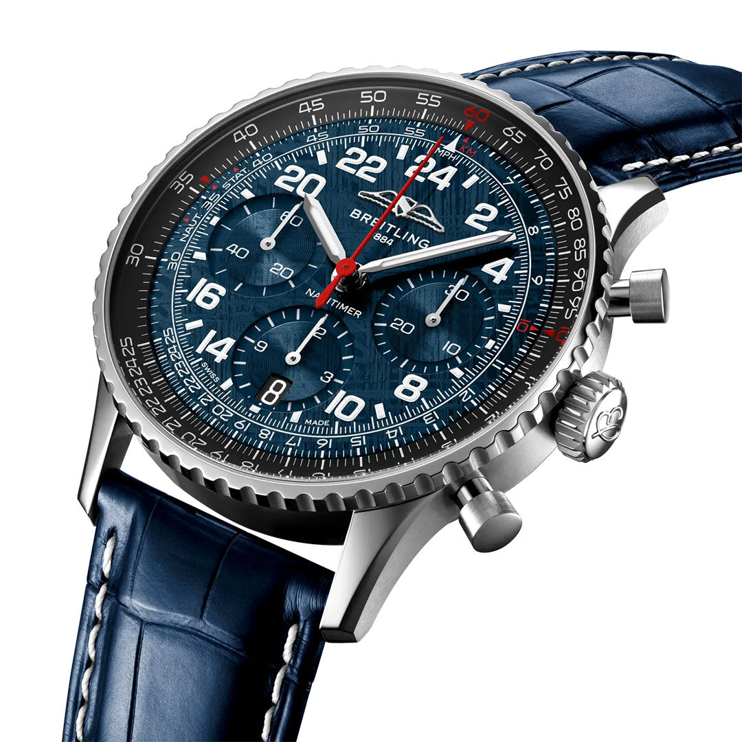 A close-up of the BREITLING Navitimer B02 Chronograph 41 Cosmonaute Artemis II shows a blue dial with white numerals, three subdials, a silver case and bezel, and a blue leather strap with visible stitching. Brand: Breitling.