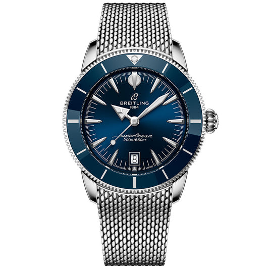 The Breitling Superocean Heritage B31 Automatic 42 features a blue dial, silver hour markers, stainless steel mesh bracelet, date display at 6 o'clock, and is water resistant to 200 meters.