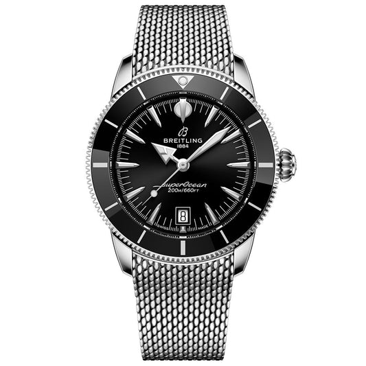 The BREITLING Superocean Heritage B31 Automatic 42 dive watch features a black dial, silver hour markers, date display at 6 o’clock, and a silver mesh bracelet, displayed against a white background.