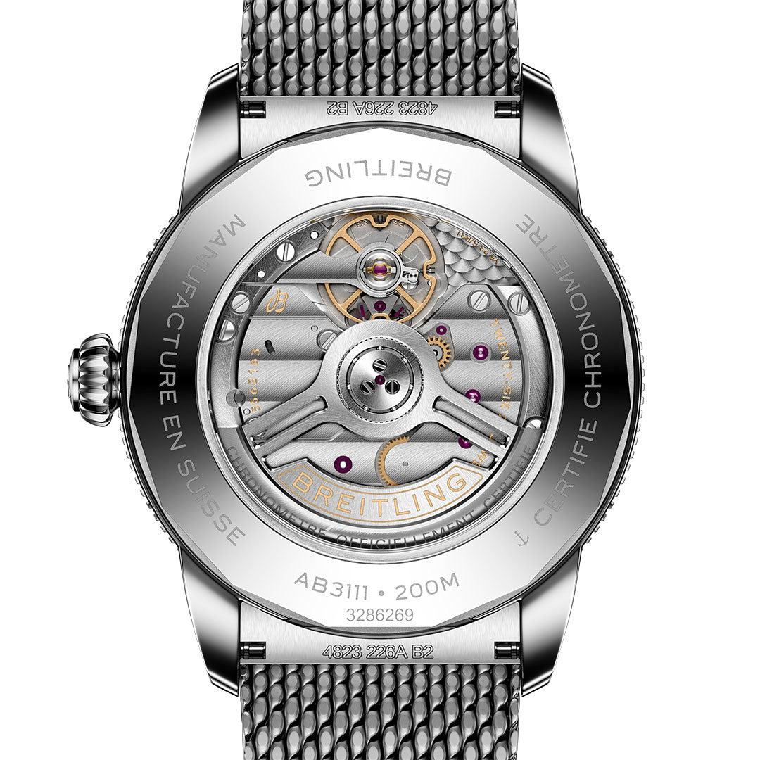 Close-up of the Breitling Superocean Heritage B31 Automatic 42's back, revealing its mechanical movement, visible gears, and metal parts through a transparent caseback bordered by engraved branding and specifications on the silver rim.