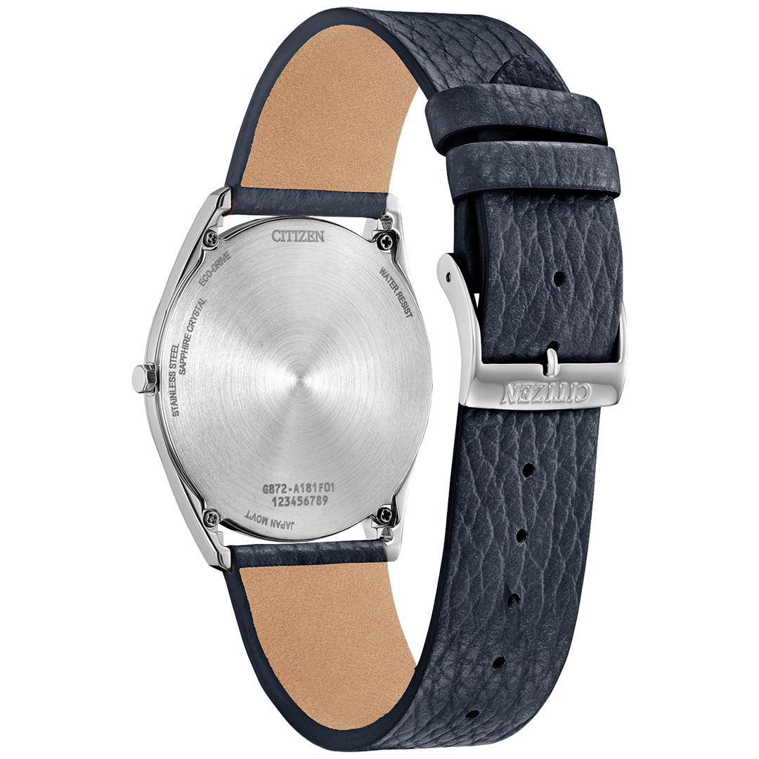 The image shows the back of a CITIZEN Suratto Eco-Drive 38.4mm Watch with a silver-tone stainless steel case and textured black leather strap, secured by a silver buckle engraved with the Citizen logo, and features model numbers and specifications on its back.