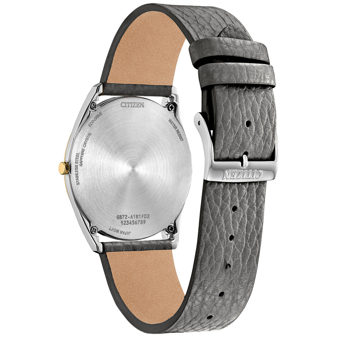 The image shows the back of a CITIZEN Suratto Eco-Drive 38.4mm Watch, showcasing a silver stainless steel case and textured gray leather strap. Citizen branding is etched on both the back and buckle, highlighting its stylish and eco-friendly design.