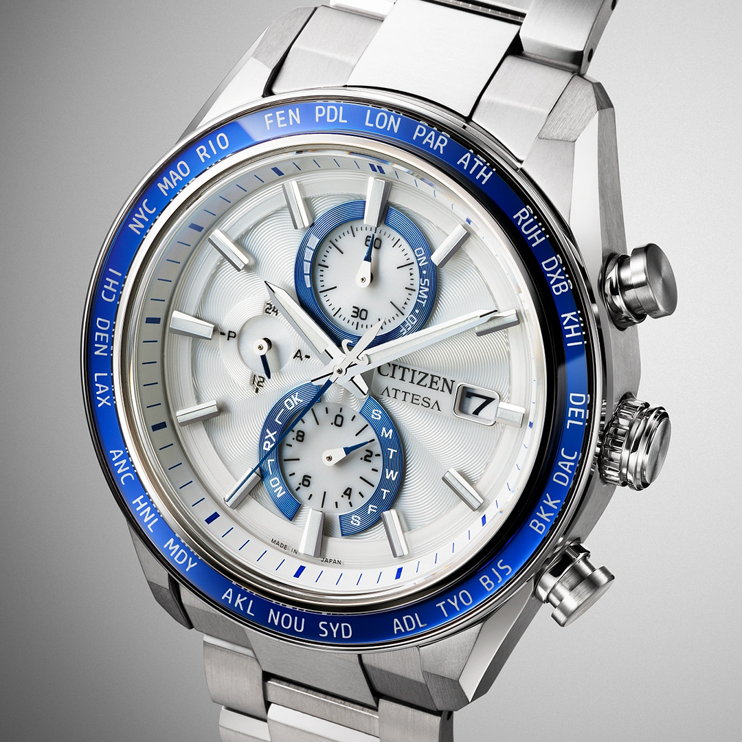 CITIZEN Attesa Atomic Time Keeping Super Titanium Eco-Drive 42mm Watch featuring an analog chronograph with a white textured dial, blue radio-controlled world-time bezel, and a silver metallic link band.