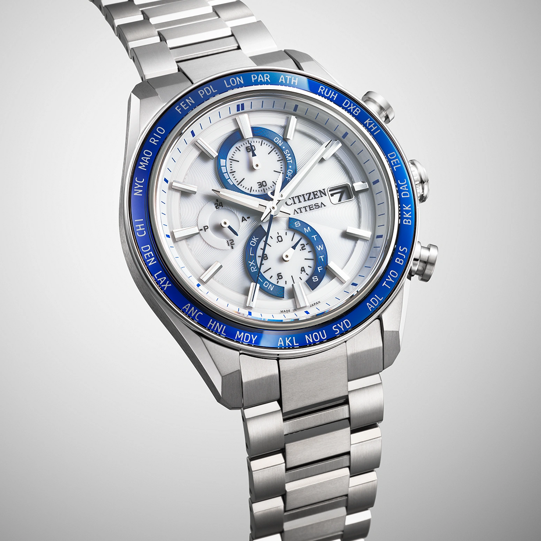 CITIZEN Attesa Atomic Time Keeping Super Titanium Eco-Drive 42mm Watch with a white dial, blue world time bezel, and a metal link bracelet.