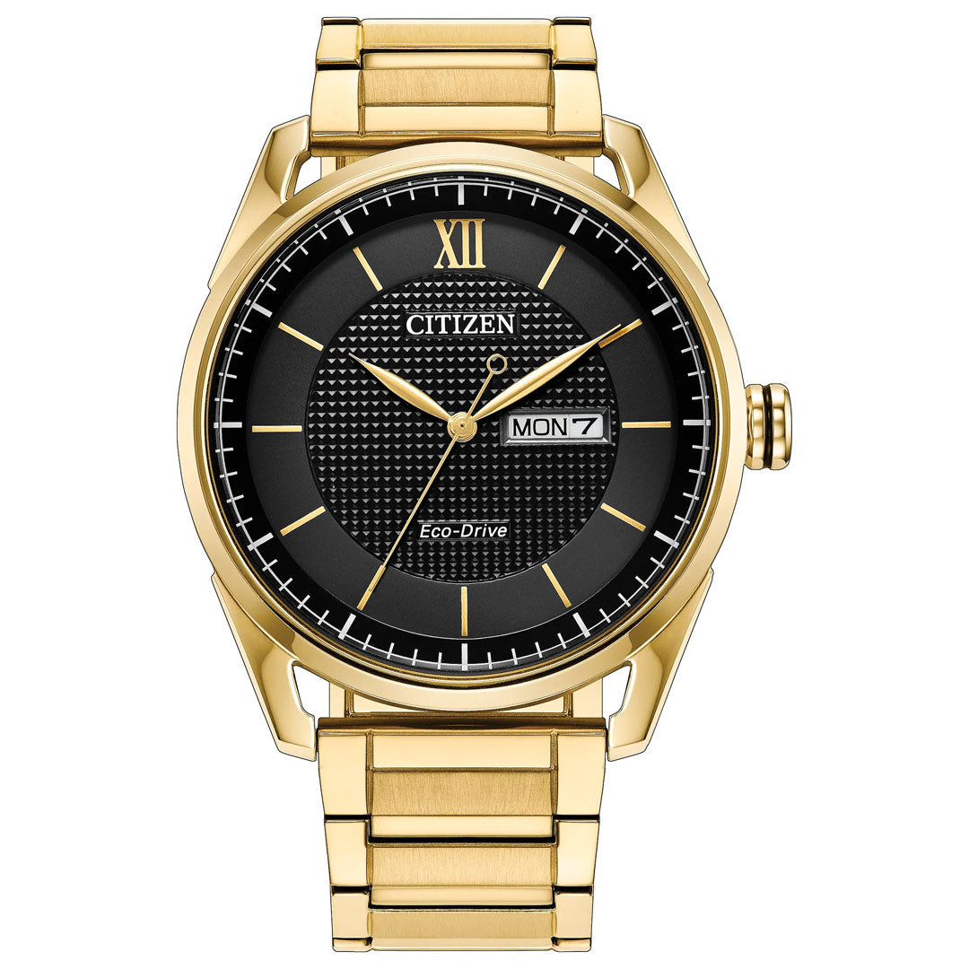 The CITIZEN Dress Classic Eco-Drive 42mm Watch features a yellow gold-tone stainless steel case, a black textured dial with gold hour markers, and a day-date window showing "MON 7" on the right. Combining elegance and functionality, this CITIZEN timepiece offers up to 100 metres of water resistance.