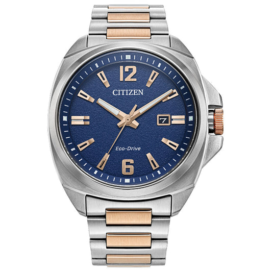 The CITIZEN Endicott Eco-Drive 42mm Watch is a sophisticated timepiece featuring a stainless steel and gold-tone bracelet. It showcases a blue dial with silver and gold hour markers, a date display at 3 o'clock, and a textured bezel that adds to its stylish design.