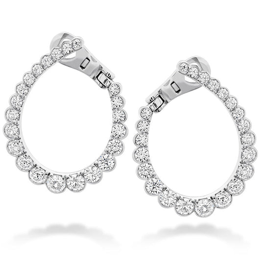 The Hearts On Fire Aerial Regal Hoop Earrings by Hearts on Fire are an elegant pair featuring a teardrop shape encrusted with sparkling round diamonds. Crafted in 18 Karat white gold, these earrings have a sophisticated hinge clasp design for easy wearing.