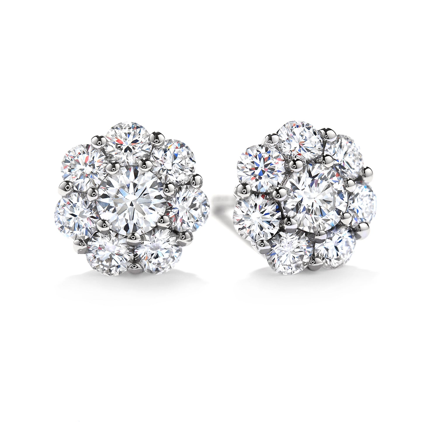 Close-up of a pair of exquisite Hearts On Fire Beloved 18K White Gold Halo Stud Earrings, showcasing multiple dazzling round diamonds in a floral arrangement. The design emphasizes an elegant and classic style with a brilliant shine, embodying the craftsmanship synonymous with Hearts On Fire.