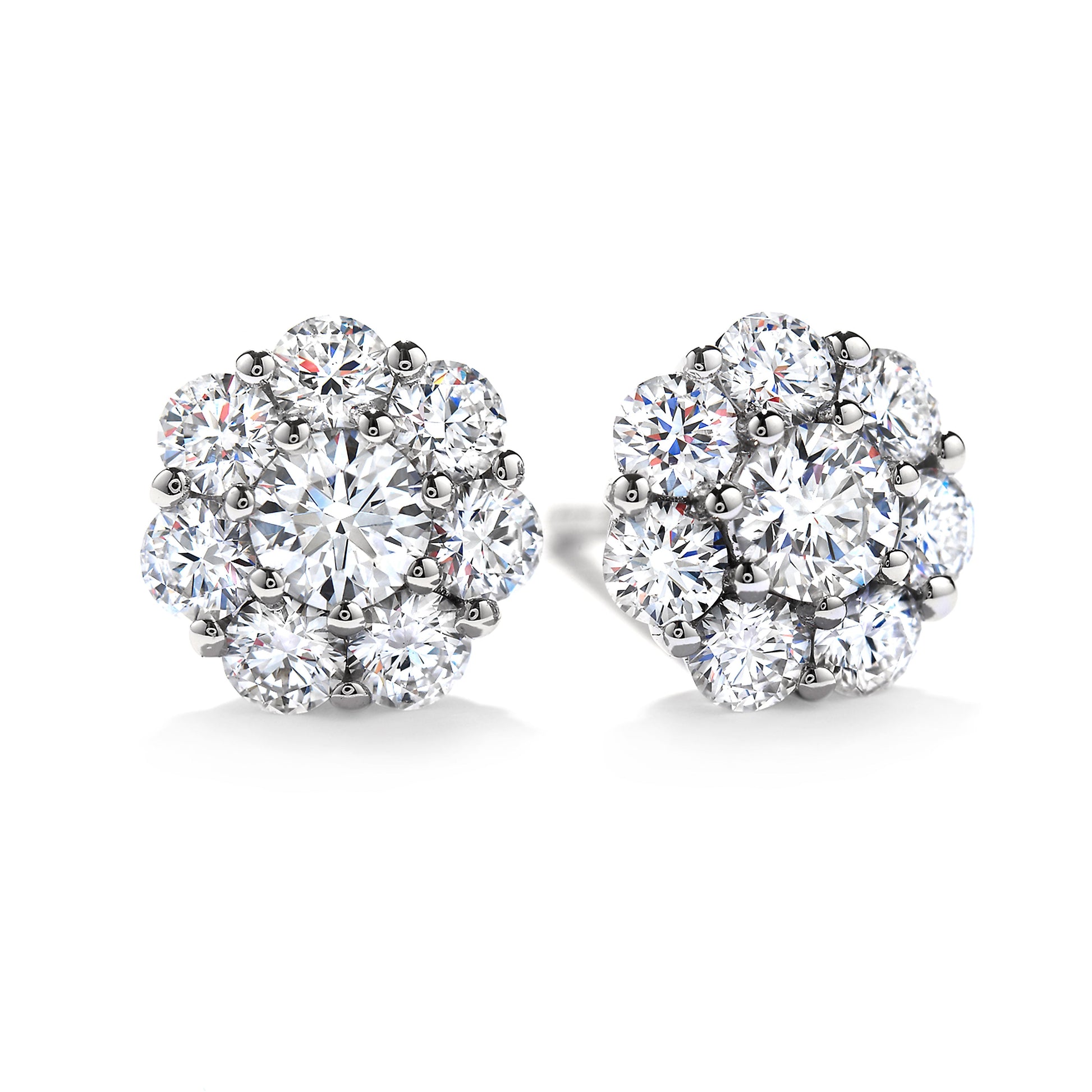 Close-up of a pair of exquisite Hearts On Fire Beloved 18K White Gold Halo Stud Earrings, showcasing multiple dazzling round diamonds in a floral arrangement. The design emphasizes an elegant and classic style with a brilliant shine, embodying the craftsmanship synonymous with Hearts On Fire.