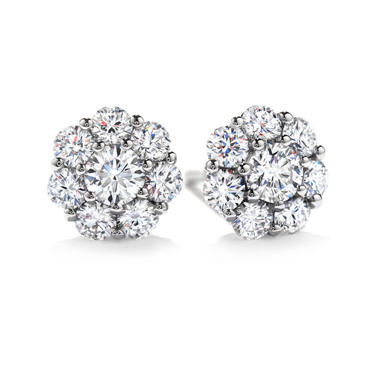 Close-up of a pair of exquisite Hearts On Fire Beloved 18K White Gold Halo Stud Earrings, showcasing multiple dazzling round diamonds in a floral arrangement. The design emphasizes an elegant and classic style with a brilliant shine, embodying the craftsmanship synonymous with Hearts On Fire.