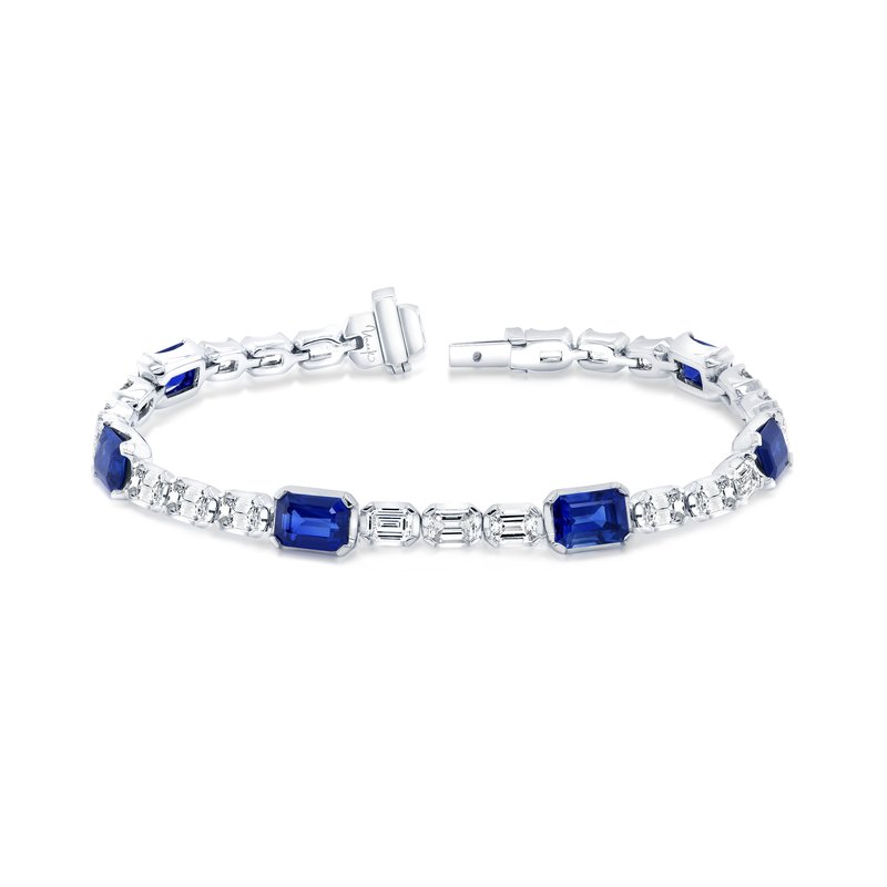 The Uneek 18K White Gold with Emerald Sapphire and Diamond Tennis Bracelet features an elegant alternating pattern of emerald sapphires and diamonds. Its visible clasp adds a touch of sophistication, making it a visually appealing accessory.