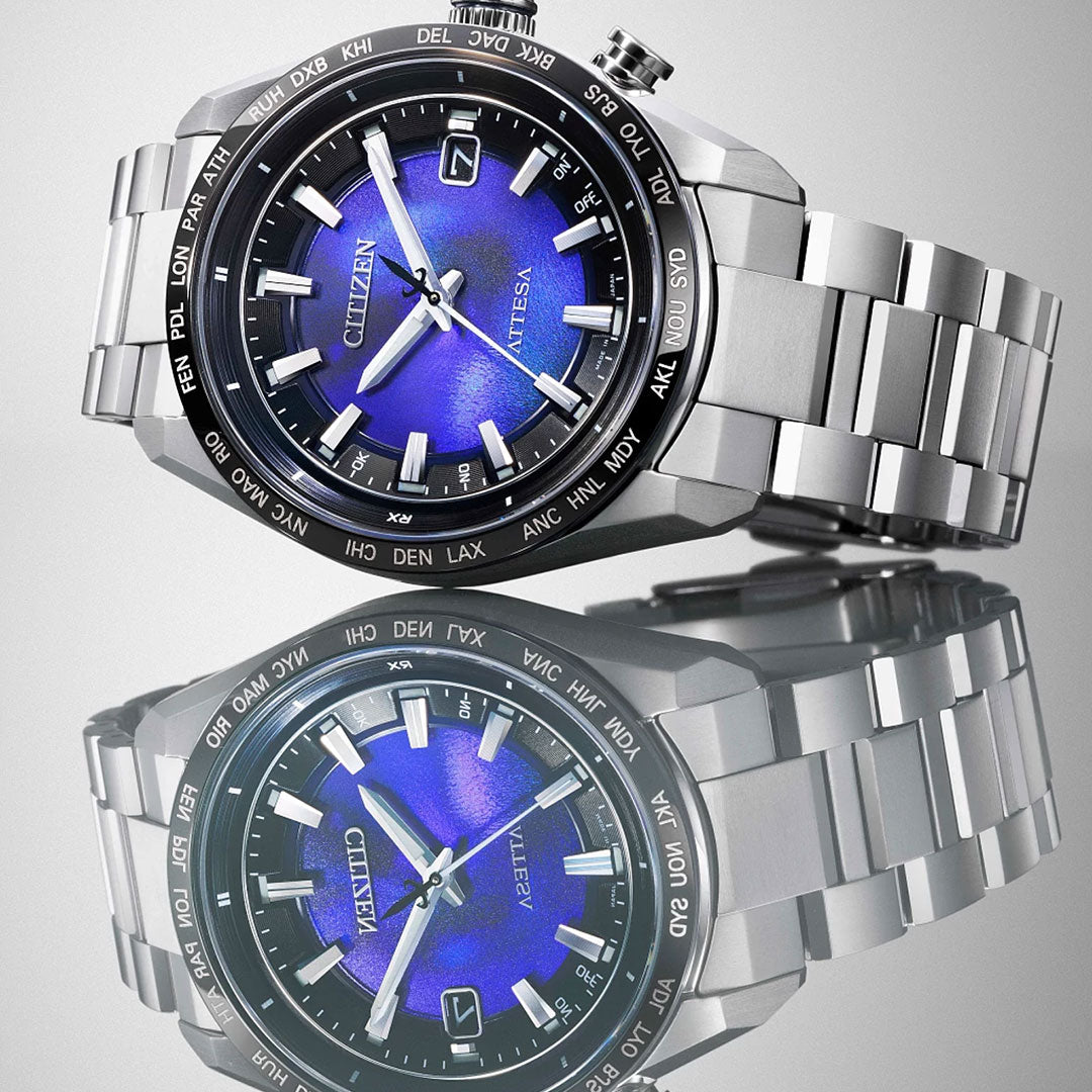 The CITIZEN Attesa Hakuto-R Atomic Time Keeping Super Titanium Limited Edition Eco-Drive 40.6mm Watch boasts a blue dial, time and date display, city bezel, and metallic strap, all beautifully reflected on a glossy surface.