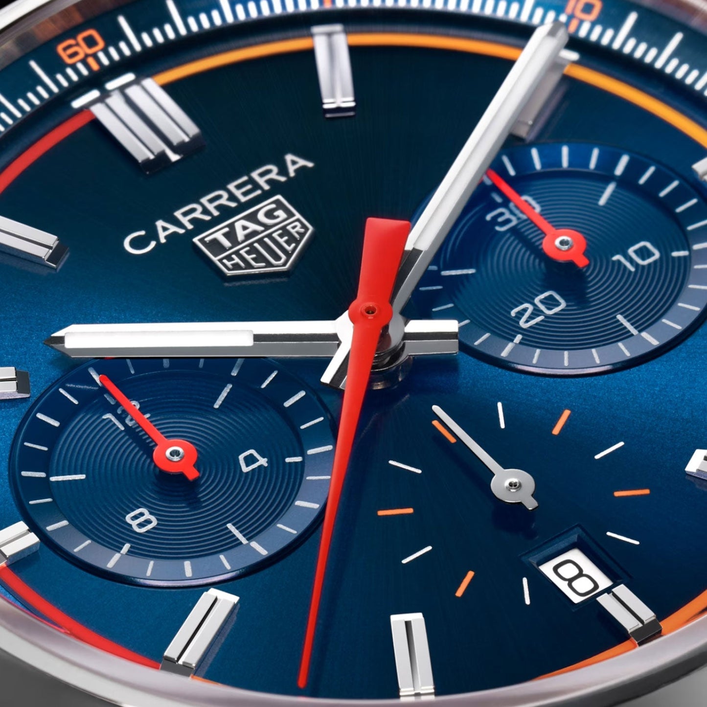 Close-up of the TAG Heuer Carrera Chronograph Automatic 42mm watch face, featuring a blue dial, red and white hands, two subdials, date window at 4 o’clock, and silver hour markers. This sophisticated timepiece by TAG Heuer is powered by the Calibre HEUER02 automatic movement for precision and style.