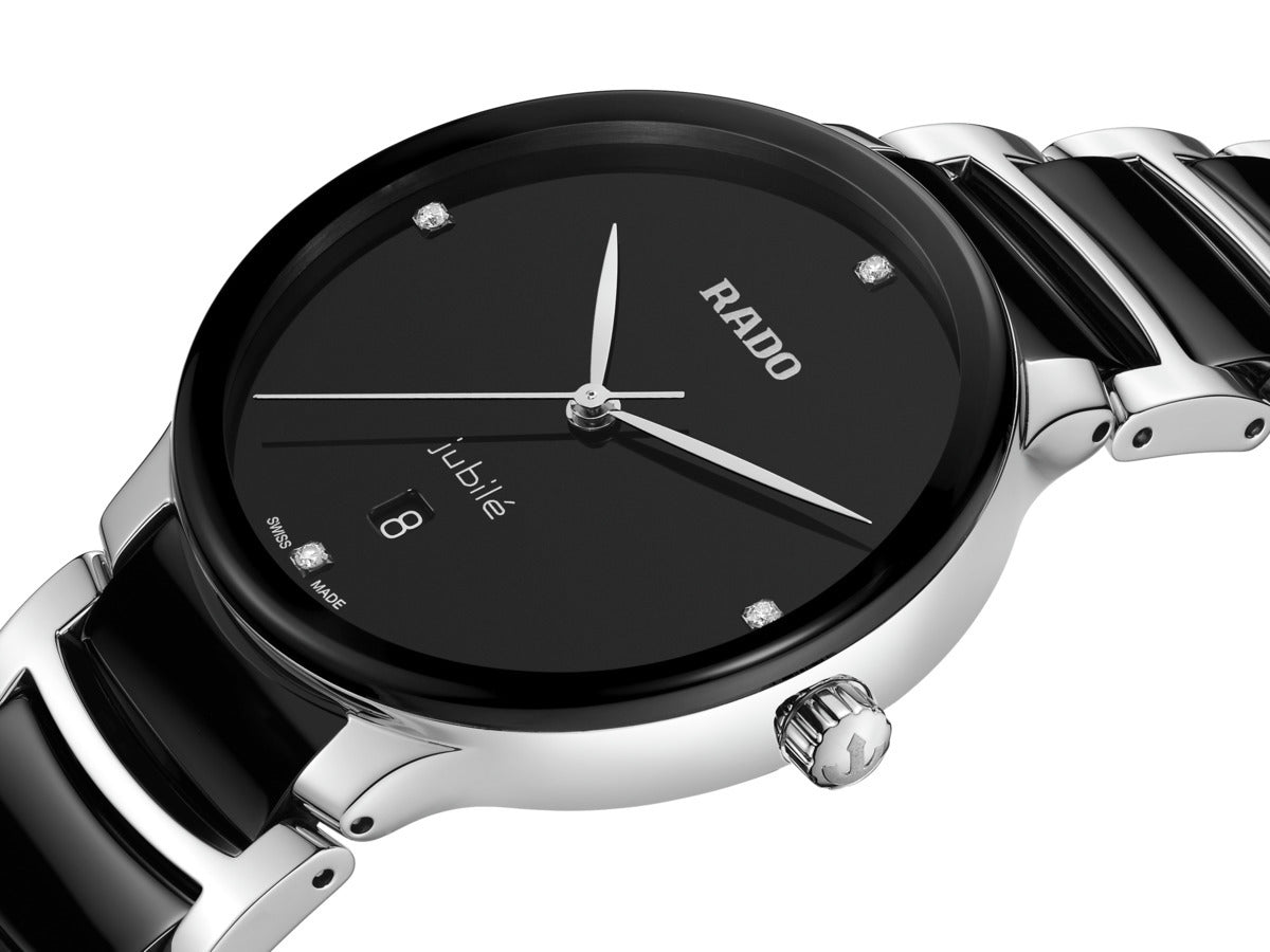 A stylish wristwatch known as the RADO Centrix Diamonds Quartz 39.5mm Watch showcases a sleek silver design with a black face. It prominently features the brand name "RADO" along with high-tech ceramic elements, complemented by simple hour markers, slender hands, a date display, and a glossy black and silver linked bracelet.