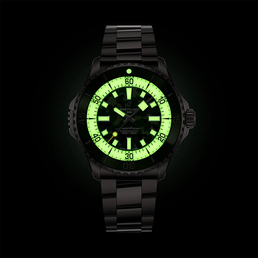 The BREITLING Superocean Automatic 46 Super Diver features a black design with a glowing green dial and luminous markers, numbers, and hands for optimal visibility in the dark, inspired by Breitling’s signature bold styling.