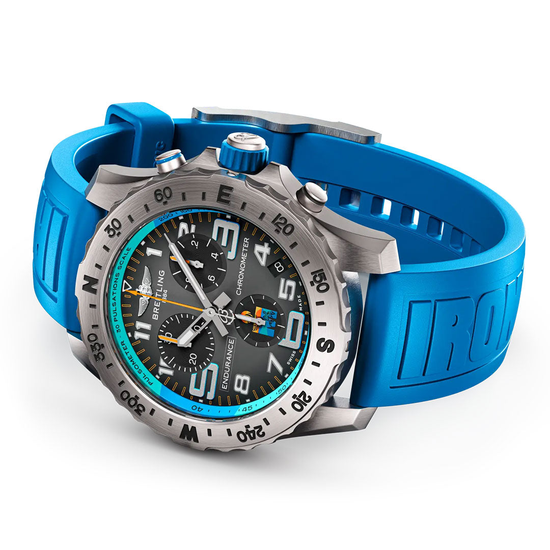 The Breitling Professional Endurance Pro World Championship 2025 features a silver case, black dial with blue accents, bold blue rubber "IRONMAN" strap, multiple subdials, and a colorful logo at the 9 o’clock position.