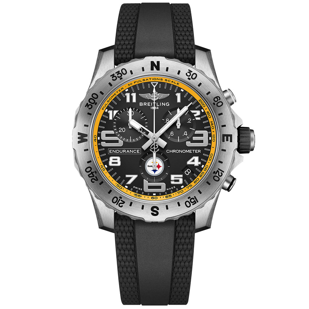 The BREITLING Endurance Pro 44 is a sporty chronograph watch featuring a black dial with yellow accents, three subdials, bold white numerals, a textured black strap, and a silver compass bezel.