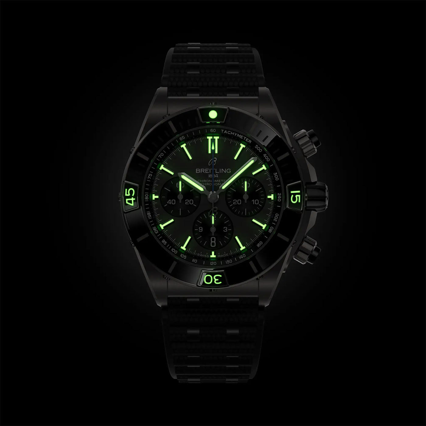 Introducing the BREITLING Super Chronomat B01 44: a sophisticated timepiece with an illuminated green display and mechanical chronograph, featuring luminescent hands. This watch includes a durable black strap and prominent tachymeter markings on the bezel, all powered by the precise Caliber 01.