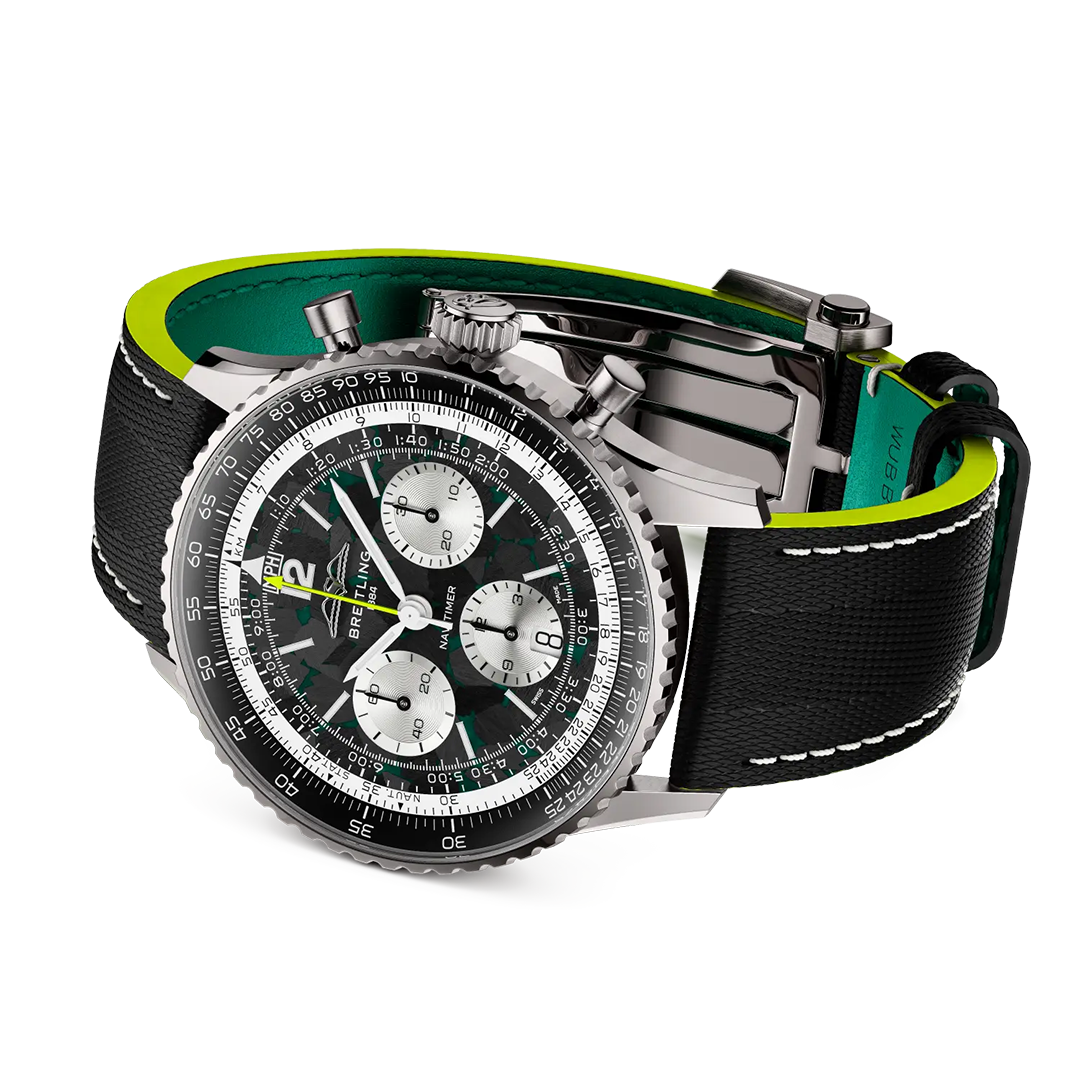 BREITLING Navitimer B01 Chronograph 43 Aston Martin Aramco Formula One Team Edition with a black dial, three silver sub-dials, and a black strap featuring neon green lining and white contrast stitching.
