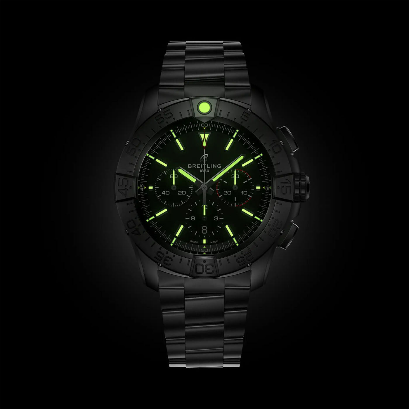 Presented against a black background, the BREITLING Super Avenger B01 Chronograph 46 wristwatch showcases a dark metal band. Its dial is highlighted with green luminescent markers and hands, driven by the precise Breitling Manufacture Caliber 01 mechanical movement, creating an enchanting glow-in-the-dark effect.